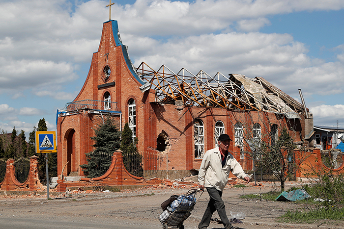 A local resident walks past a church heavily damaged during Ukraine-Russia conflict in the southern port city of Mariupol, Ukraine April 28, 2022.